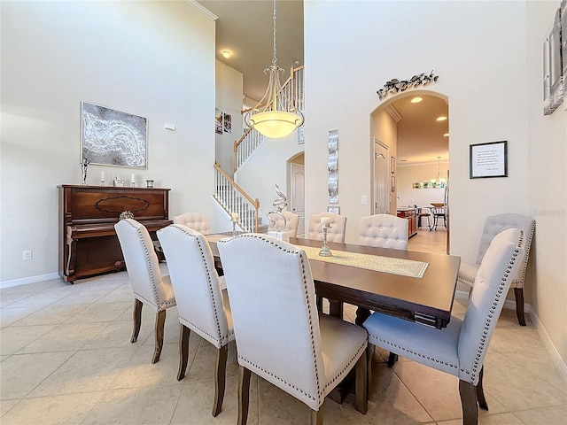 tiled dining area featuring a towering ceiling