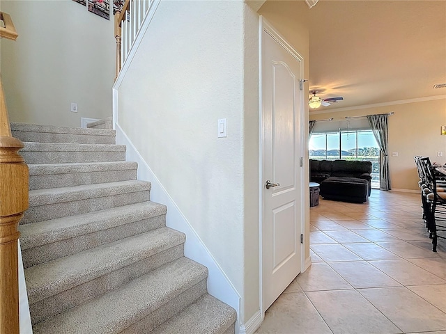 staircase featuring crown molding and tile patterned floors