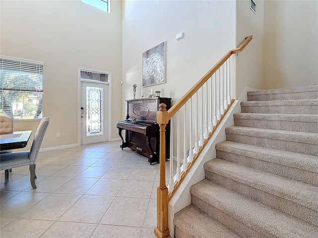 tiled foyer entrance with a towering ceiling