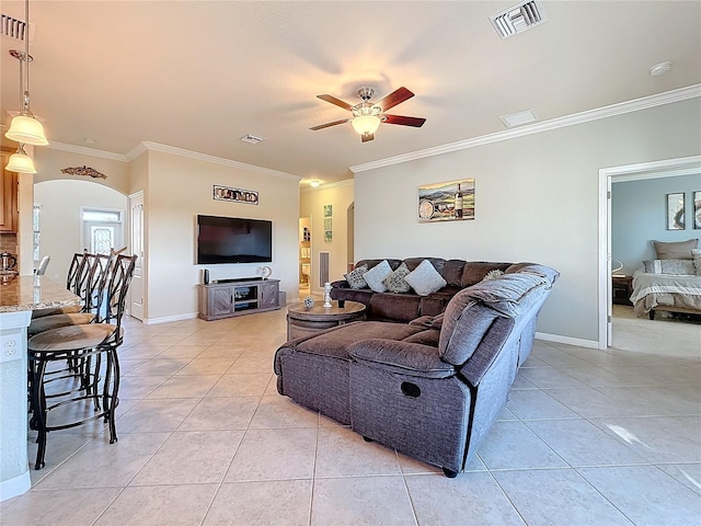 tiled living room with ornamental molding and ceiling fan