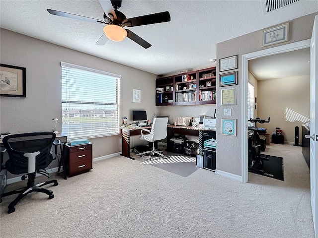 office space with ceiling fan, light colored carpet, and a textured ceiling