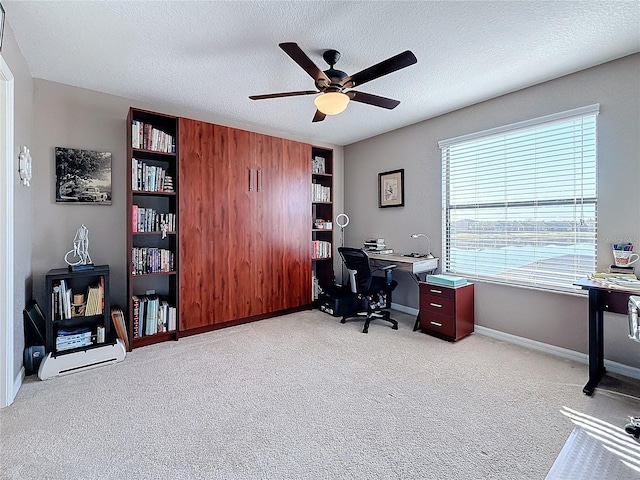 carpeted office with ceiling fan and a textured ceiling