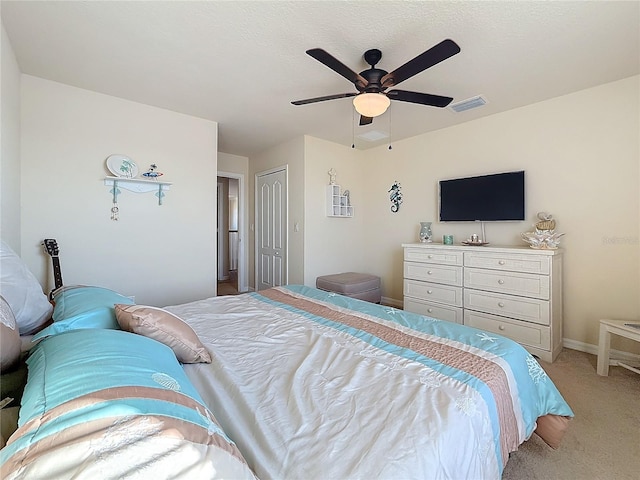 carpeted bedroom with ceiling fan and a closet