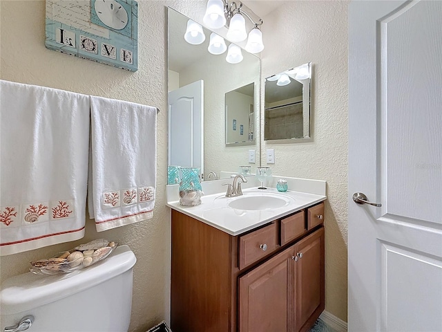 bathroom with vanity, a chandelier, and toilet