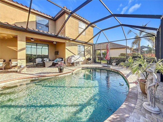 view of pool featuring ceiling fan, a patio, and glass enclosure