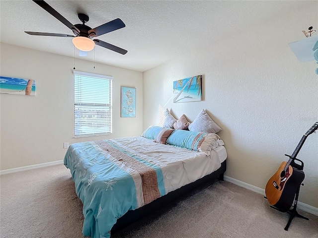 bedroom with light carpet, baseboards, a ceiling fan, and a textured ceiling