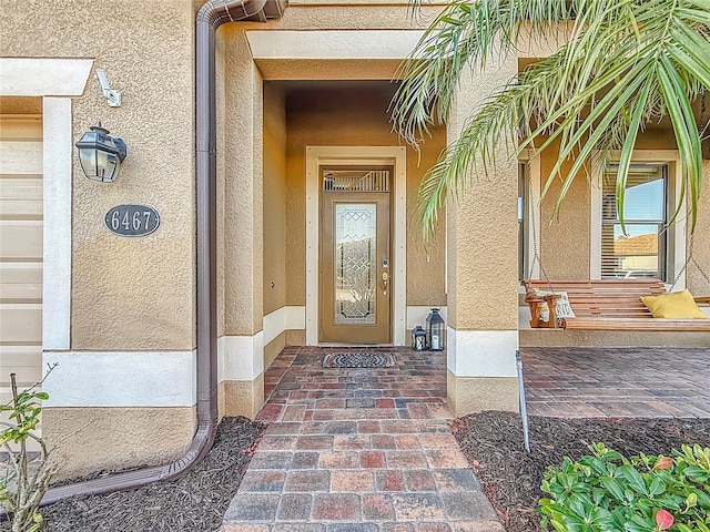 entrance to property featuring stucco siding