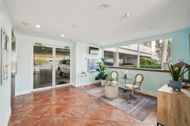 sitting room featuring a wall mounted air conditioner and a wealth of natural light