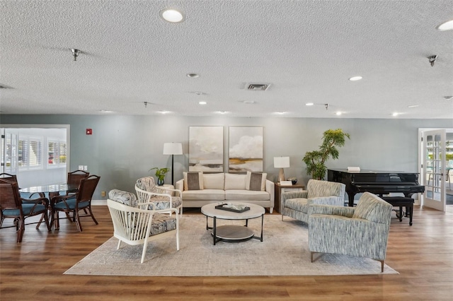 living room with a textured ceiling and light wood-type flooring