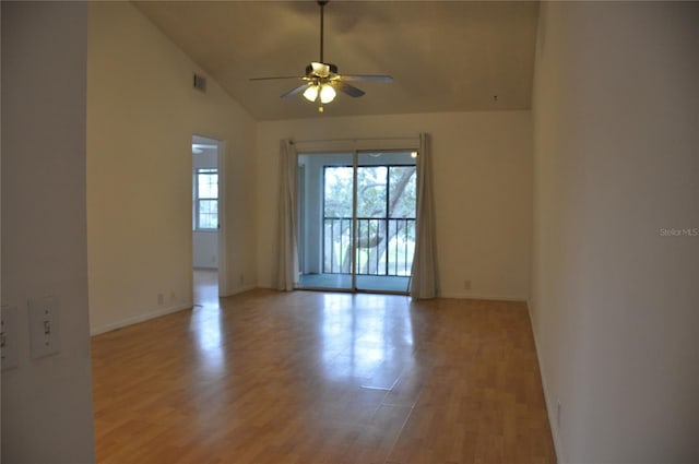 unfurnished room featuring lofted ceiling, plenty of natural light, ceiling fan, and light wood-type flooring