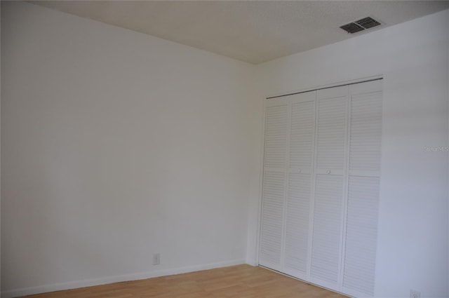 unfurnished bedroom with wood-type flooring and a closet