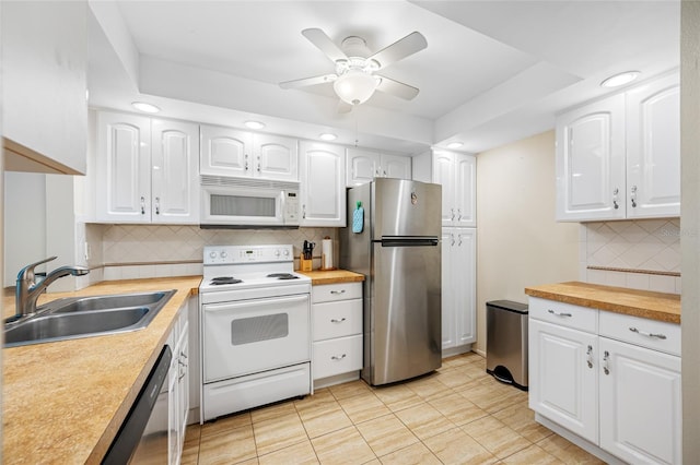 kitchen with stainless steel appliances, tasteful backsplash, sink, and white cabinets