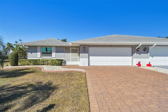 ranch-style house with a garage and a front yard