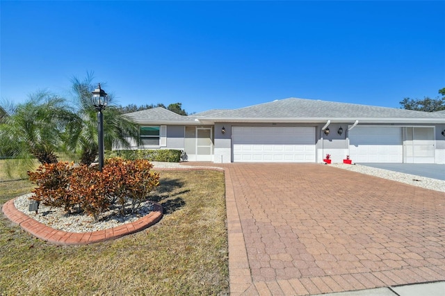 ranch-style house with a garage and a front lawn