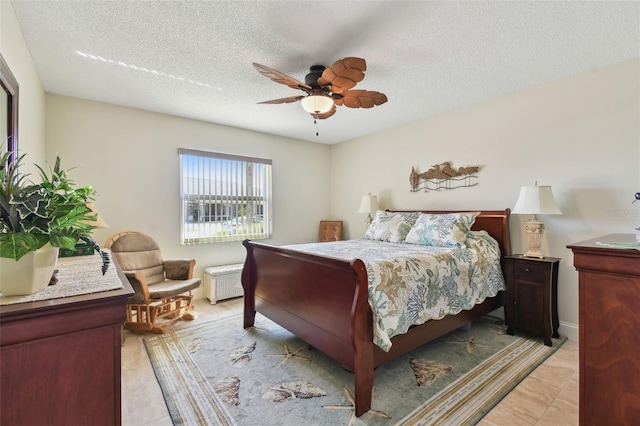 bedroom with light tile patterned flooring, ceiling fan, and a textured ceiling