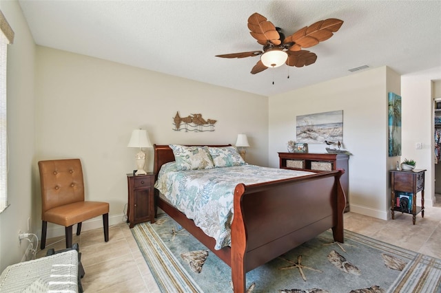 tiled bedroom with a textured ceiling and ceiling fan