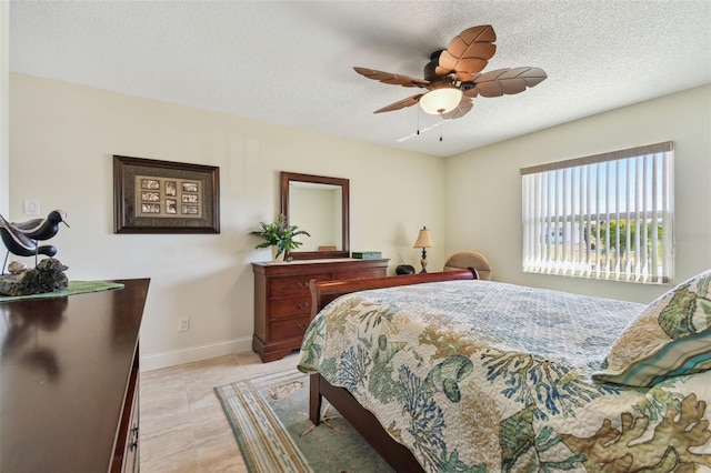 tiled bedroom with ceiling fan and a textured ceiling