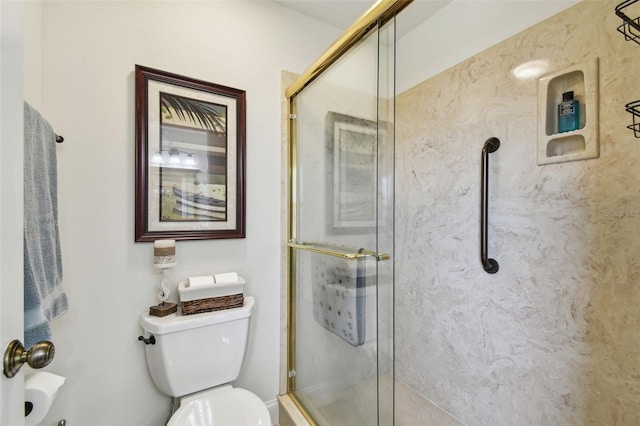 bathroom with toilet and a shower with shower door