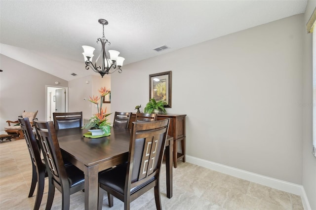 dining area featuring lofted ceiling, a textured ceiling, and an inviting chandelier