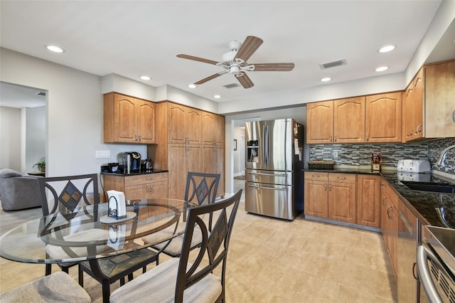 kitchen with tasteful backsplash, sink, stainless steel fridge, and ceiling fan