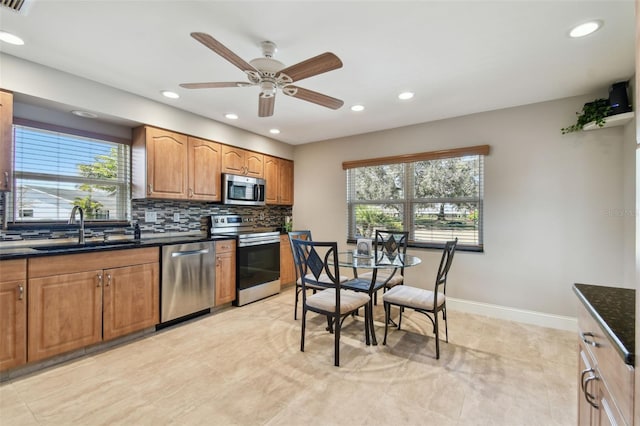 kitchen featuring appliances with stainless steel finishes, sink, backsplash, and plenty of natural light