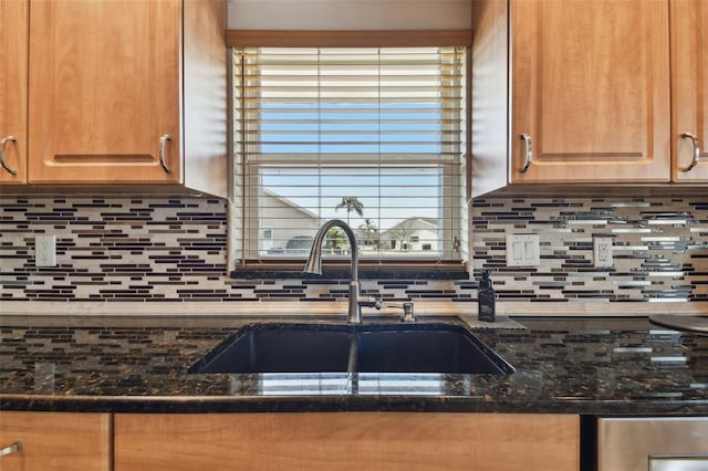 kitchen with tasteful backsplash, sink, and dark stone counters