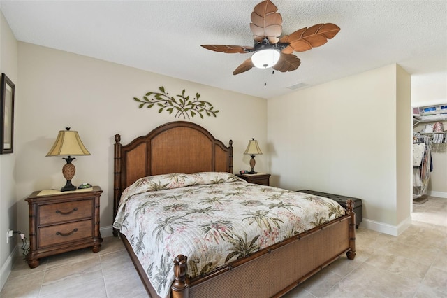 tiled bedroom featuring a spacious closet, ceiling fan, and a closet