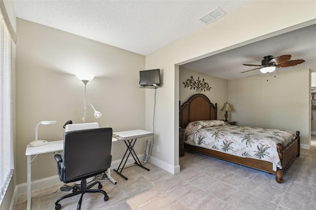 tiled bedroom with ceiling fan and a textured ceiling