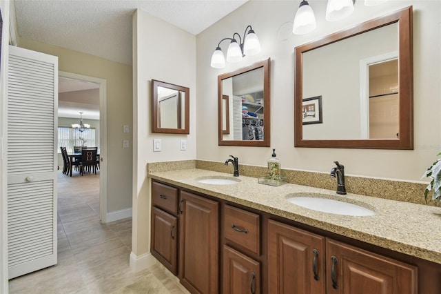 bathroom with tile patterned floors, vanity, and a textured ceiling