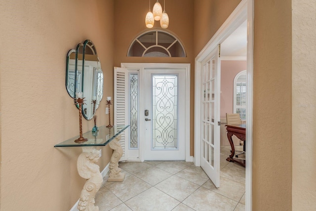 tiled foyer with a notable chandelier