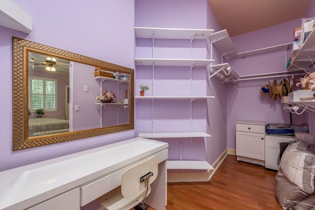 spacious closet with hardwood / wood-style floors and ceiling fan