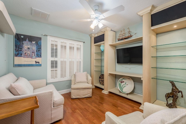 living room featuring wood-type flooring and ceiling fan