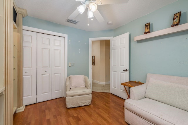 living area with hardwood / wood-style flooring and ceiling fan