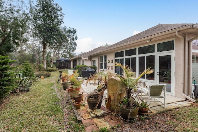 rear view of property featuring a patio area and a lawn