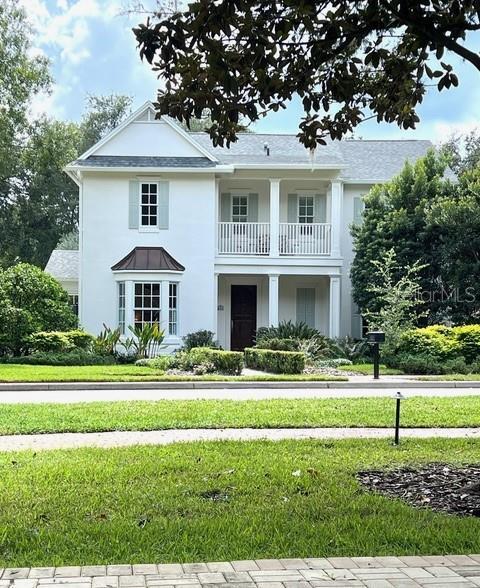 view of front of home featuring a balcony and a front yard