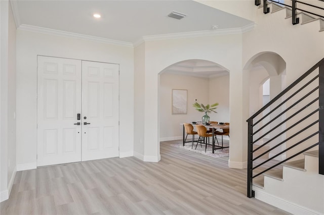 foyer with ornamental molding and light wood-type flooring