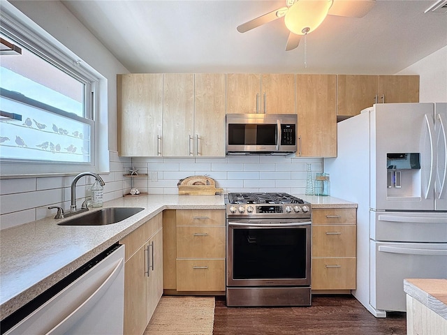 kitchen with sink, decorative backsplash, light brown cabinets, and appliances with stainless steel finishes