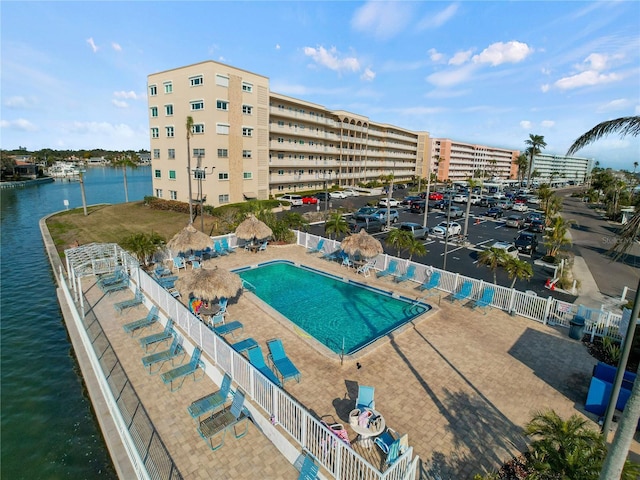 view of swimming pool featuring a water view and a patio