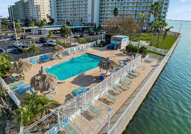 view of swimming pool featuring a water view and a patio