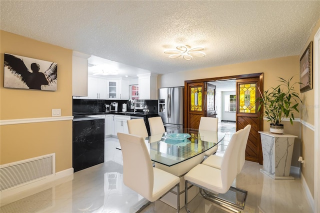 tiled dining room with a wealth of natural light and a textured ceiling