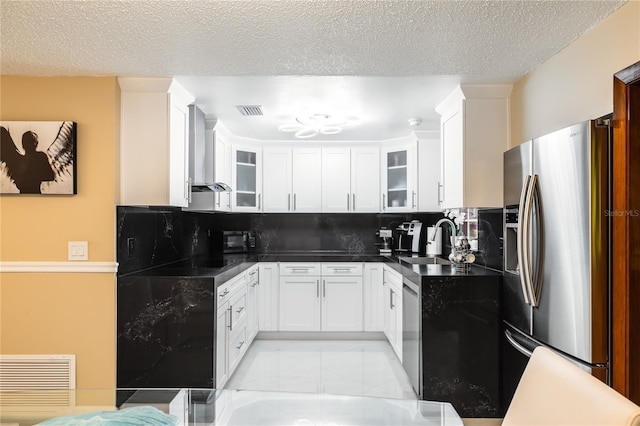 kitchen featuring sink, appliances with stainless steel finishes, white cabinets, decorative backsplash, and wall chimney exhaust hood