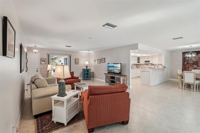 living room featuring a chandelier and light tile patterned flooring