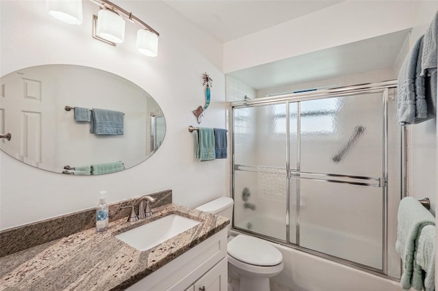 full bathroom with vanity, enclosed tub / shower combo, and toilet