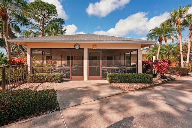 rear view of property featuring a sunroom