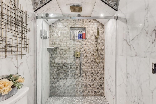 bathroom with toilet, lofted ceiling, tile walls, and walk in shower