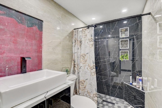 bathroom with toilet, curtained shower, sink, and tile walls