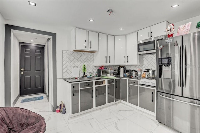 kitchen featuring stainless steel appliances, white cabinetry, and tasteful backsplash