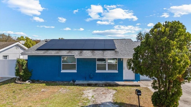 view of side of property with a yard and solar panels