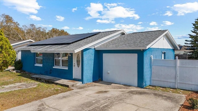 view of front of home featuring a garage and solar panels