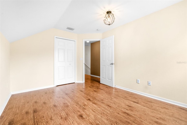 interior space with hardwood / wood-style flooring and vaulted ceiling